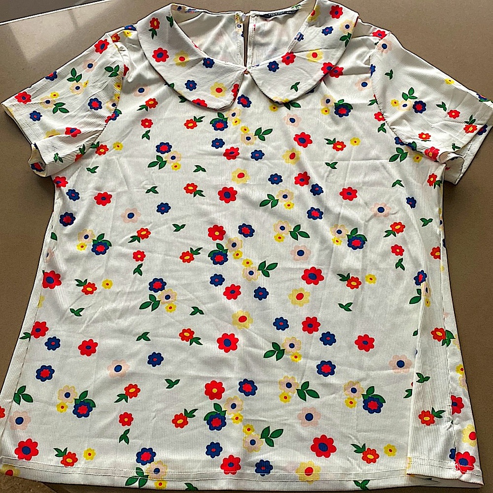 Multicoloured flower print jersey/rayon top, with a peter pan collar.